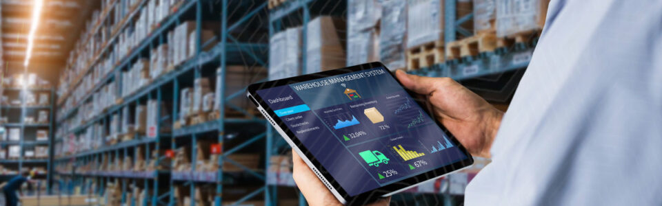 Warehouse employee in a warehouse viewing supply chain contracts on a digital tablet.