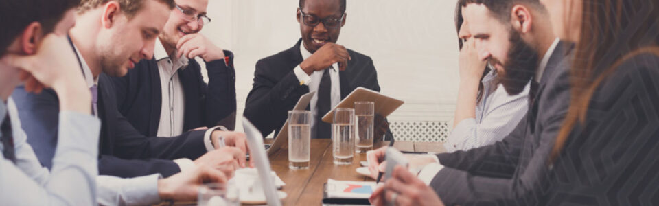 A diverse team of professionals negotiating SaaS contracts, gathered in a modern office setting, focused on strategic discussions.