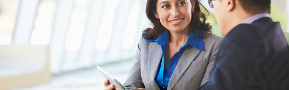 business colleagues with digital tablet discuss navigating compliance with enterprise contract management systems