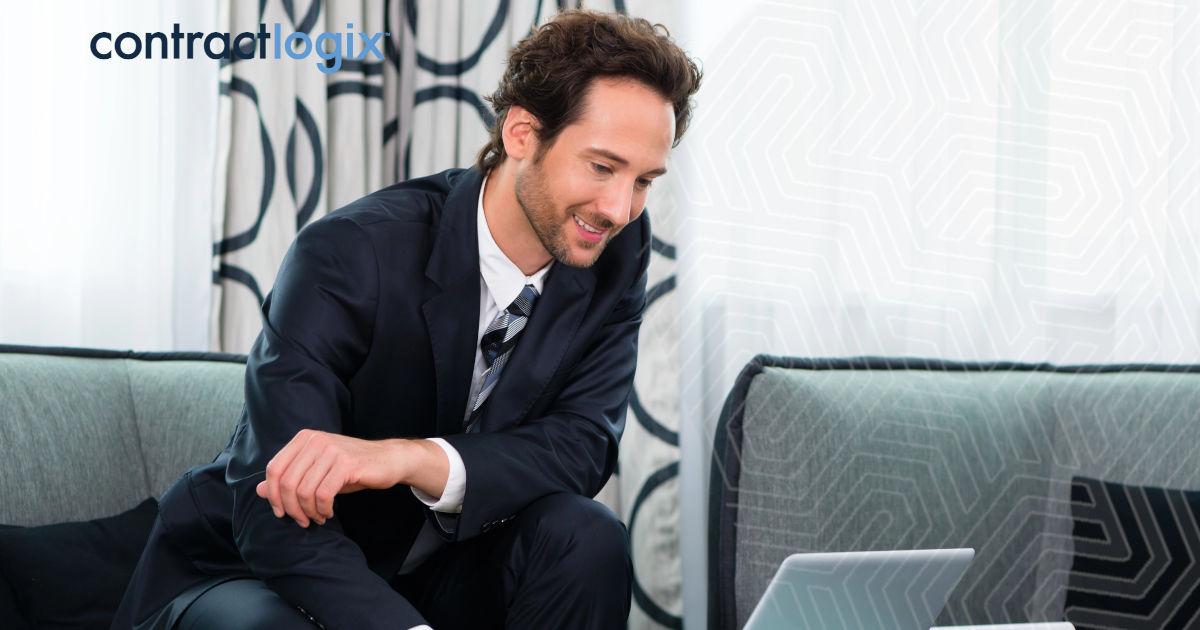 businessman smiles while using business contract management software on his laptop computer