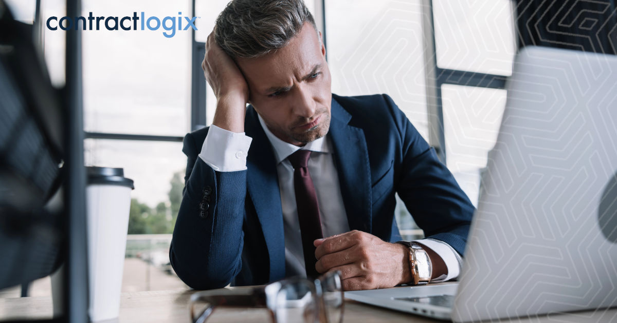 frustrated businessman stares at computer screen after falling victim to common Pitfalls in Contract Lifecycle Management