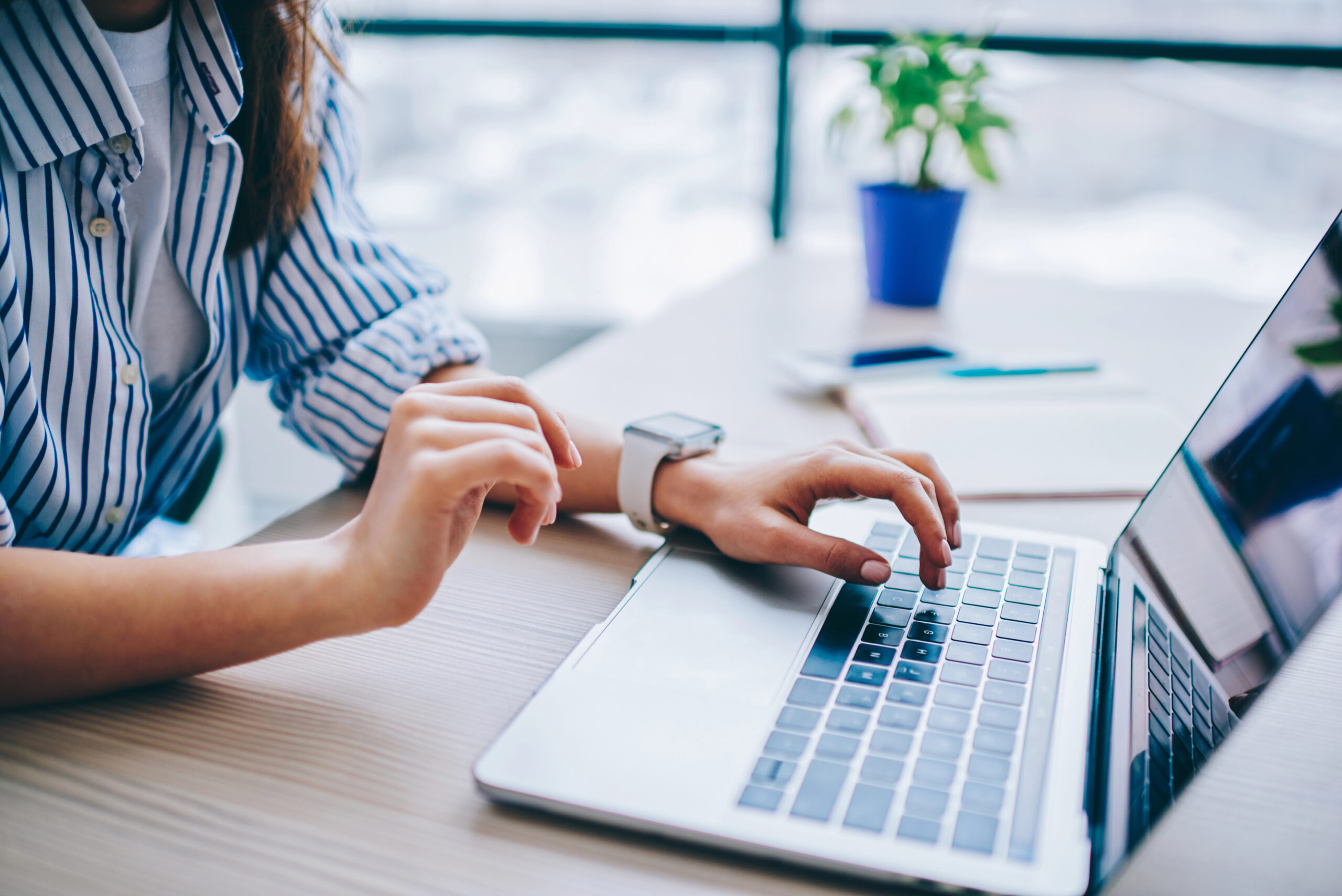 cropped image of female hands using the computer to access an automated contract management system
