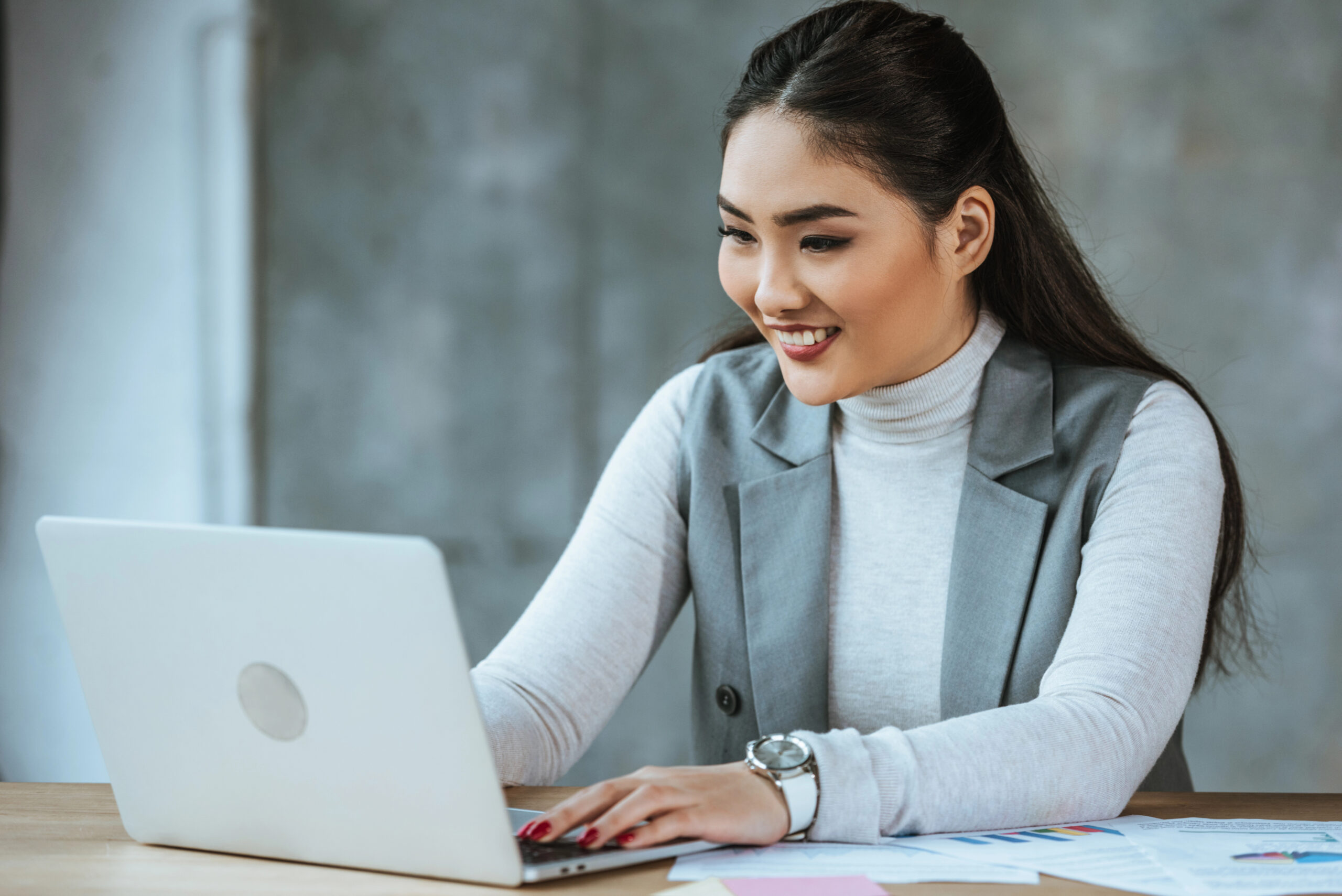 young businesswoman using a contract management tool on laptop in office