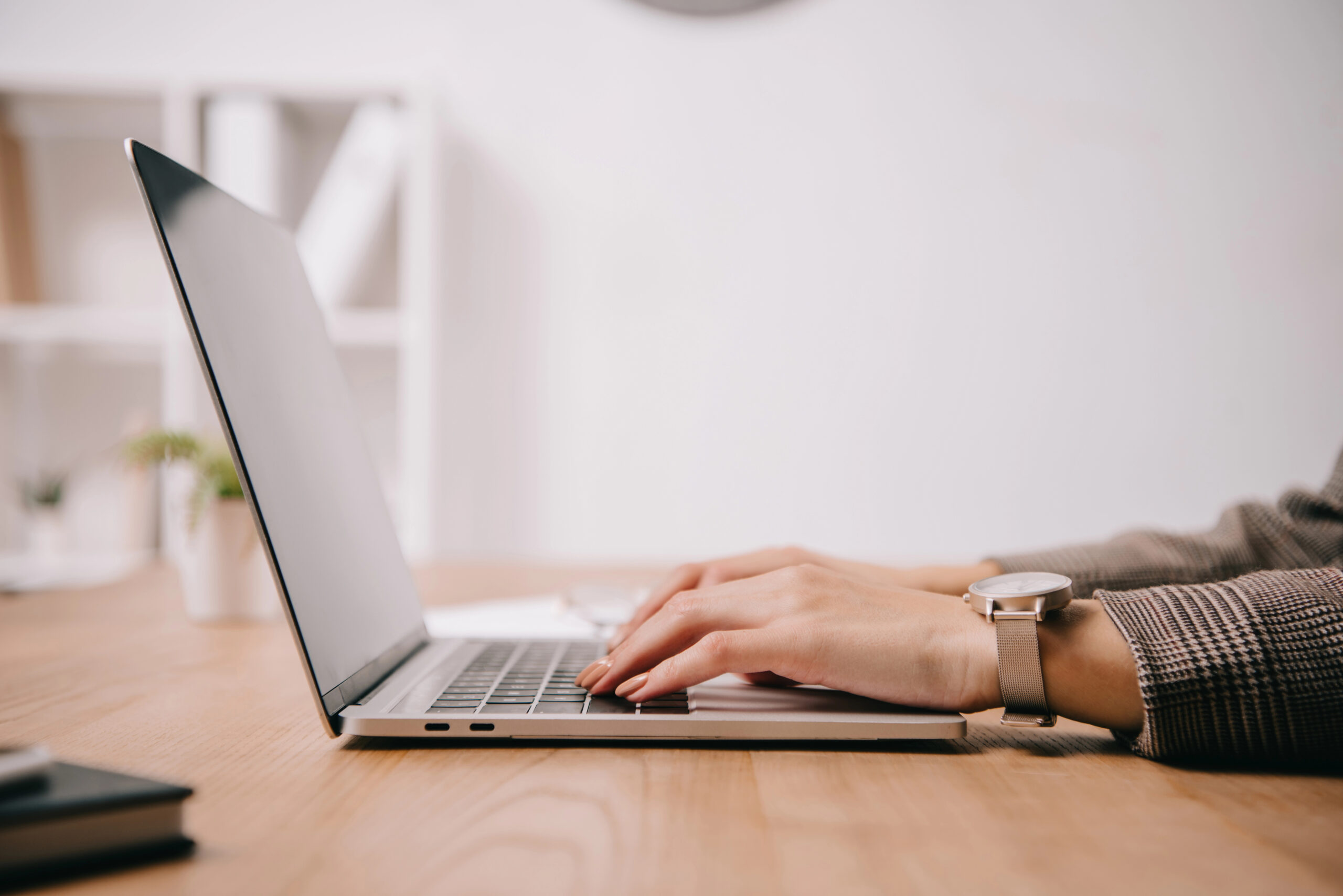 cropped view of businesswoman working and sitting at desk while using contract repository software