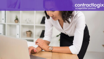 woman stands at desk with laptop computer and learns about the Guide to Contract Management.​