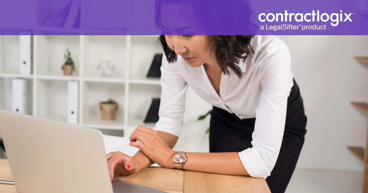 woman stands at desk with laptop computer and learns about the Guide to Contract Management.​