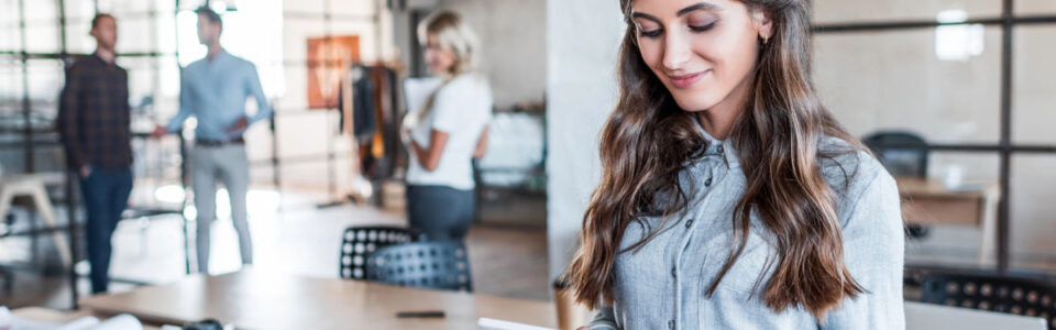 smiling young businesswoman using digital tablet to discover How CLM Platforms Ensure Business Continuity