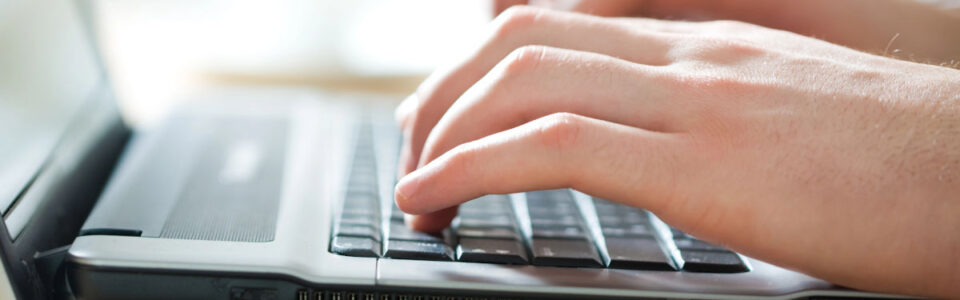 cropped shot of person using laptop computer to learn about contract management system (CMS)